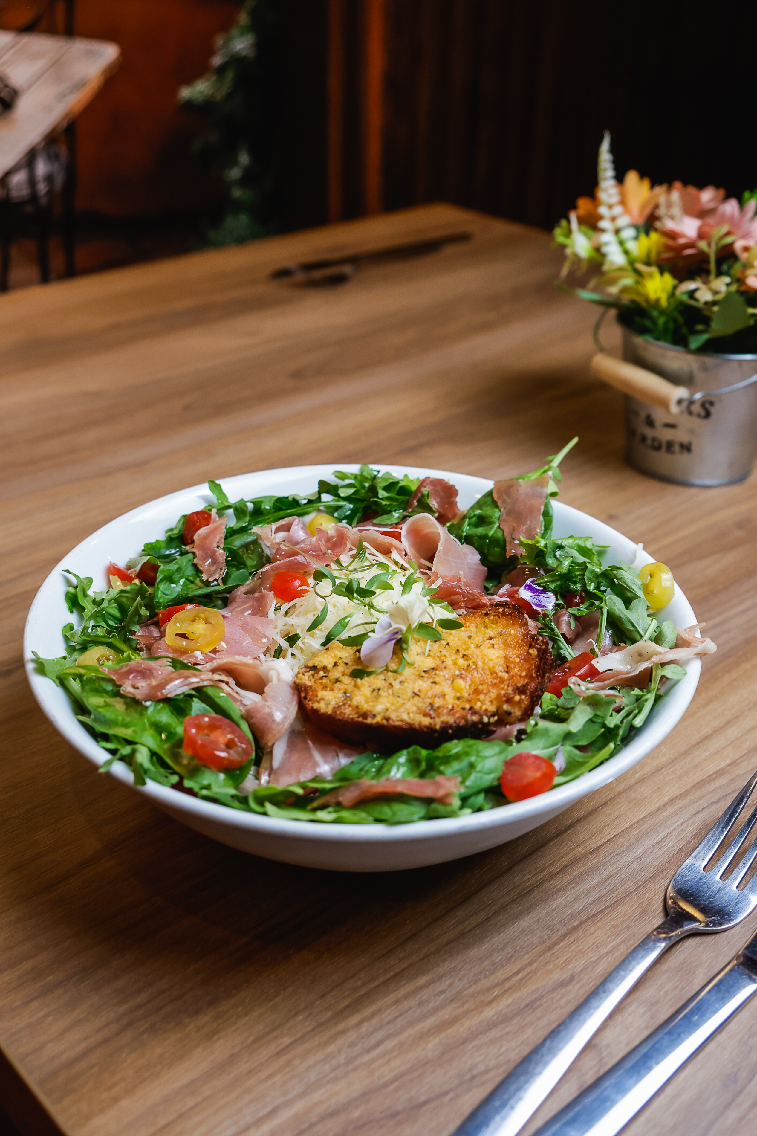 Ensalada con jamón serrano, arúgula, tomate cherry y pan tostado al parmesano en Luigi's